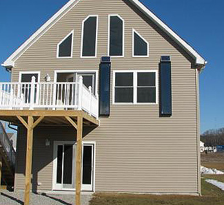 Two vertically mounted BISFA heating panels, with PV panels on a New England style home under construction